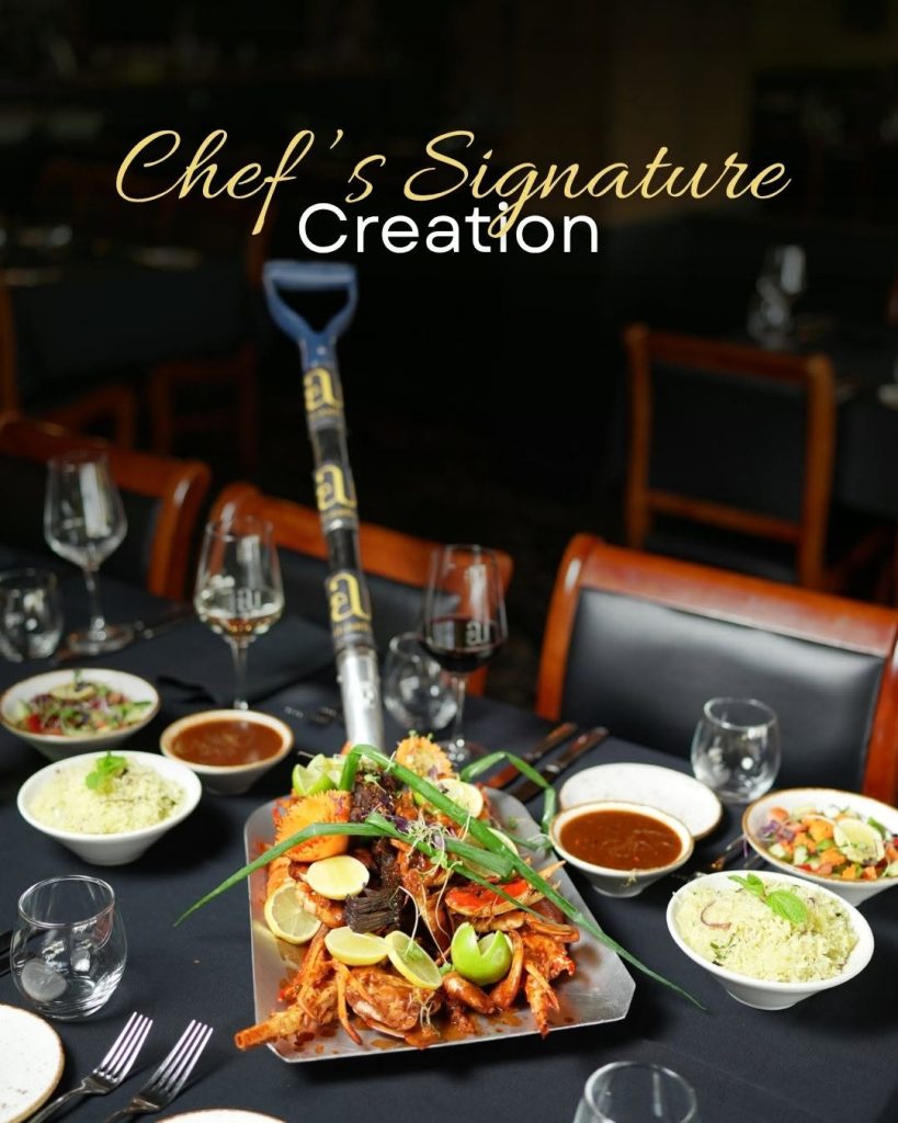 Chef’s signature seafood platter served with fresh lemon, rice, sauces and side salads on a restaurant table.